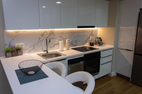 斯科普里DIAMOND OF SKOPJE JB的厨房配有白色橱柜、水槽和桌子