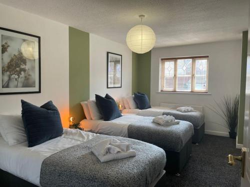 卡迪夫Ramson's Homestead by M-GroupSA的一间设有两张床和两张搁脚凳的房间