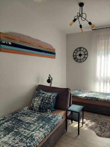 格但斯克Blue - Bastion Wałowa的带沙发、床和时钟的客厅