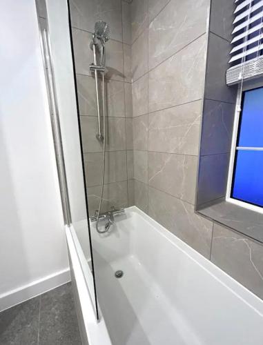 芬奇利2 Bedroom Luxury Appartment的带淋浴和白色浴缸的浴室