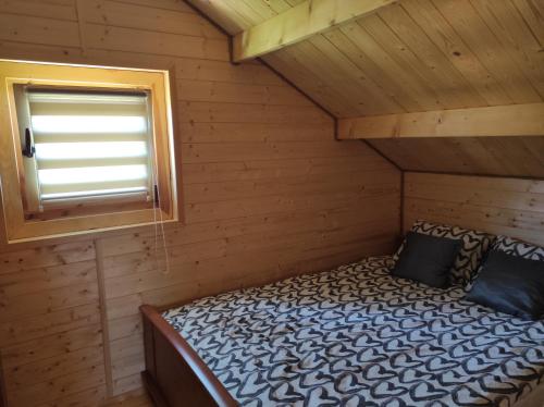 维尔卡瑟Domek u Emi的小木屋内的一张床位,设有窗户