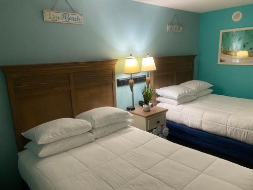 默特尔比奇Oceanfront Oasis的两张位于酒店客房的床,拥有蓝色的墙壁