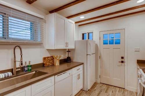 凤凰城The Urban Cowboy Bunk House的厨房配有白色橱柜和冰箱。