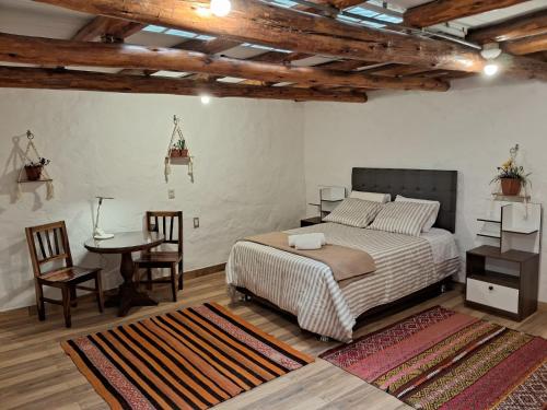 库斯科KOSKO Casa Hotel的卧室配有一张床和一张桌子及椅子