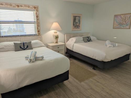 克利尔沃特Sea Club Condo #405的一间卧室设有两张床、一盏灯和一扇窗户。