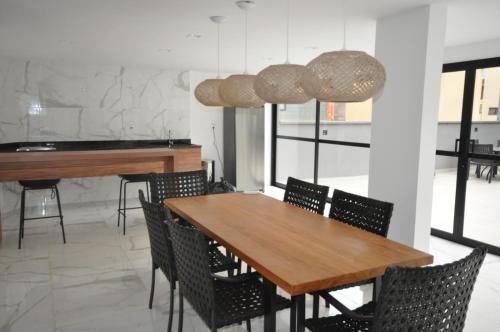 波苏斯-迪卡尔达斯Studio no centro的一间带木桌和椅子的用餐室