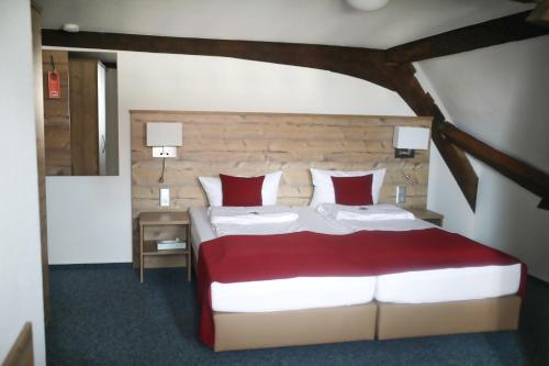 斯特滕阿卡顿玛Gasthaus Hotel zum Kreuz的一间卧室配有一张带红色和白色枕头的大床