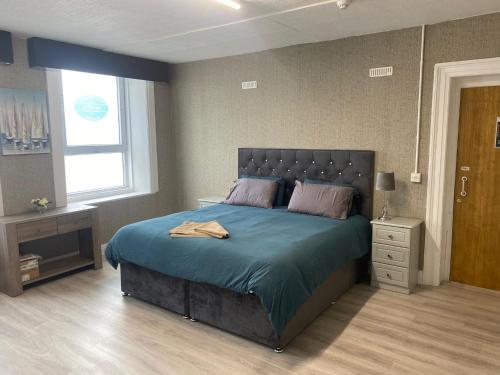 沃特福德Waterford Hostels Ltd的一间卧室配有一张带蓝色毯子的大床