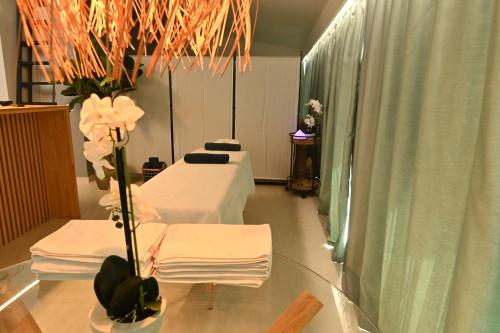 索瓦塔H49 Jacuzzi Penthouse-Adults only的一间医院房间,配有两张床和一张带鲜花的桌子