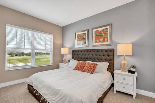 奥兰多NEW awesome dream house, 5 Min to Disney的一间卧室配有一张带两盏灯的床和一扇窗户。