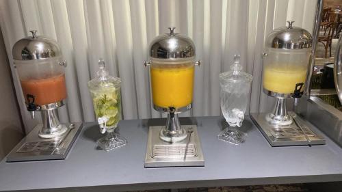 贝洛奥里藏特维勒塞莱斯蒂纳活动公寓式酒店的一张桌子,上面有三种不同的饮料