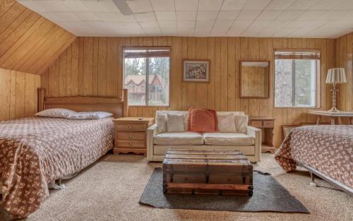 大熊湖096 - Sawmill Cove Lodge的一间卧室配有两张床、一张沙发和一把椅子