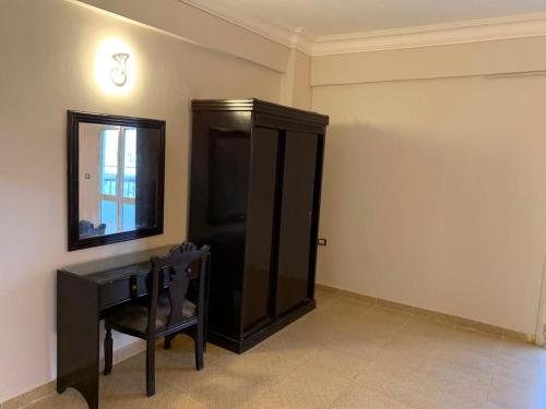 马萨阿拉姆Red sea Hotel Marsa Alam的配有梳妆台、镜子和椅子的房间