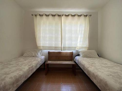 瓦兹特佩克Casa en Oaxtepec的两张床位于带窗户的房间内