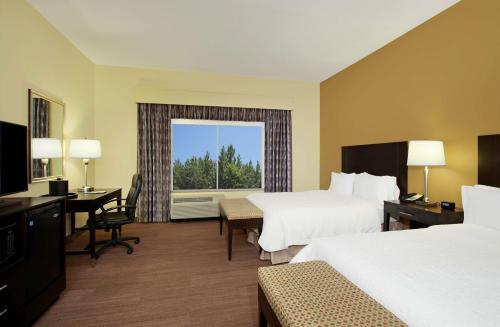 Tucker温菲尔德希尔顿恒庭酒店的酒店客房设有两张床、一张书桌和一个窗户。
