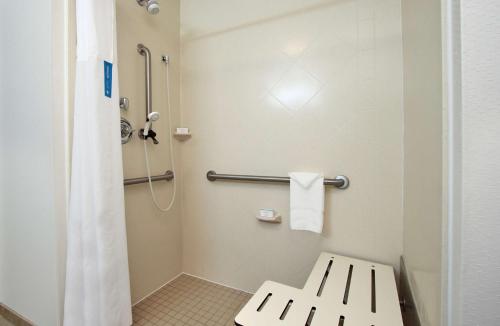 Tucker温菲尔德希尔顿恒庭酒店的带淋浴的浴室以及带长凳的卫生间。