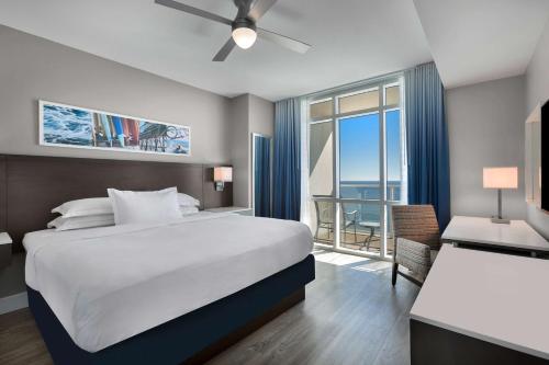 默特尔比奇Hilton Grand Vacations Club Ocean 22 Myrtle Beach的一间卧室设有一张大床和一个大窗户