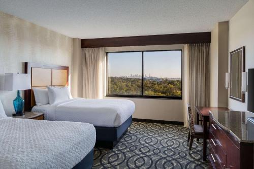 达拉斯达拉斯爱田希尔顿合博套房酒店的酒店客房设有两张床和大窗户。