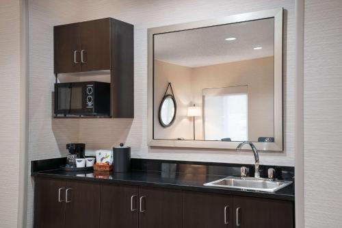 拉夫兰洛夫兰希尔顿恒庭酒店的厨房配有水槽和镜子