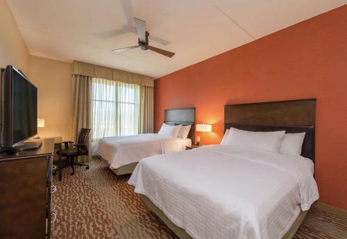 BerlinHomewood Suites by Hilton Boston Marlborough的酒店客房设有两张床和一台平面电视。
