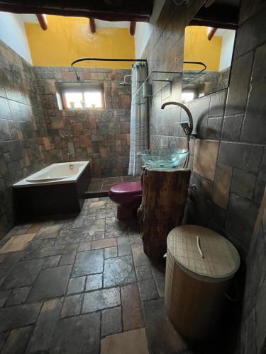 乌鲁班巴Casa Rica Paz的带浴缸和水槽的石质浴室