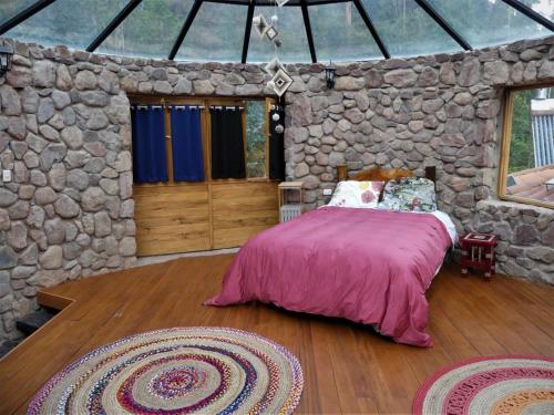 乌鲁班巴Casa Rica Paz的卧室配有一张石墙床