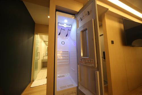 釜山Hound Hotel Minam的客房设有电视、冰箱和浴室。