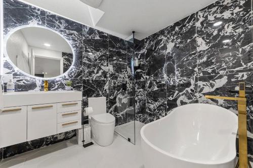 柯克兰NEW Fully Remodeled, Updated 8 beds, 3 baths High End Modern Home Private WaterFront的黑白浴室设有水槽和镜子