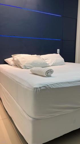 马卡帕Casa Almirante Premium的一张白色的床,配有蓝色床头板和白色床单