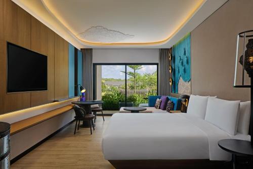 努沙杜瓦Renaissance Bali Nusa Dua Resort的酒店客房设有一张大床和一台电视机。