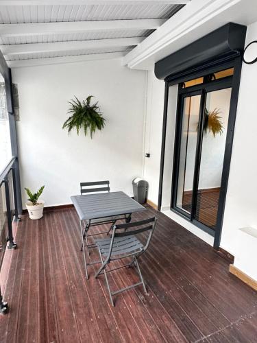 皮特尔角城Cyrus appartements的铺有木地板的庭院配有桌椅