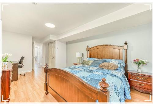 加蒂诺Leila`s place-Basement apartment in private home的一间卧室配有一张带蓝色棉被的木床