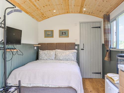 WaltonPartridge Hut-uk44850的一间卧室设有一张床、一台电视和一个窗口。