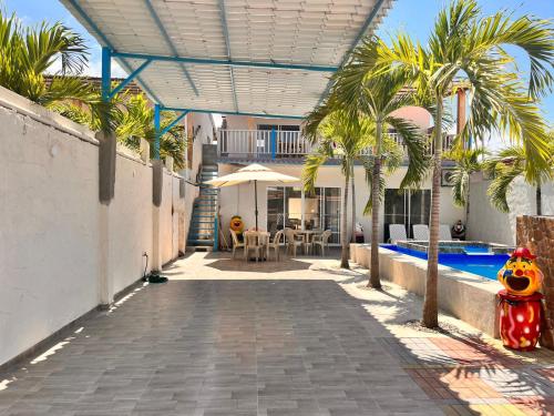 普拉亚斯Casa Halley #4 con vista al mar y piscina , 2 pisos - Villamil Playas , Data de Villamil的一座带游泳池和棕榈树的房子