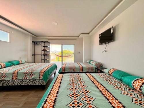 普拉亚斯Casa Halley #4 con vista al mar y piscina , 2 pisos - Villamil Playas , Data de Villamil的客房设有两张床和一台平面电视。