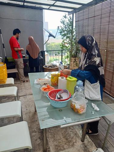 安邦Sky Chalet at Axis Next To LRT Pandan Indah Ampang的坐在桌子上,吃着食物的女人