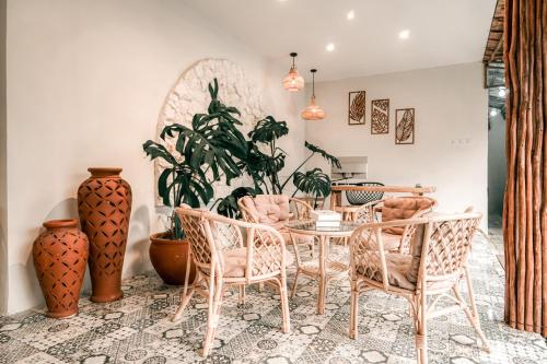 科贾扬Demoska Villa Jogja With Privatepool的一间带桌椅和花瓶的用餐室