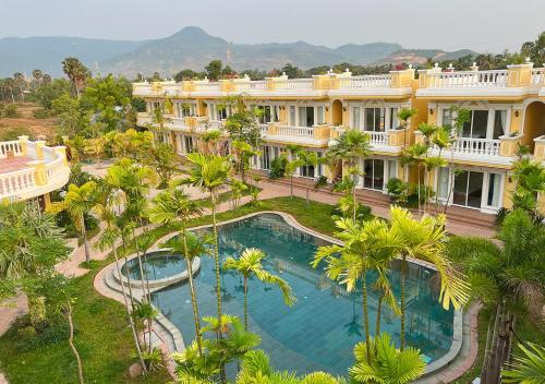 贡布Sokchea Kampot Hotel的享有度假村的空中景致,设有游泳池和棕榈树
