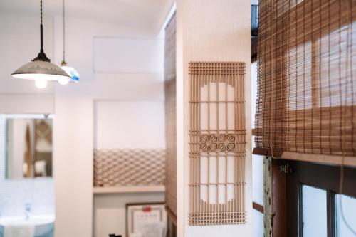 台南錦小路包棟民宿 Nishikikoji inn的一间设有窗户和吊灯的墙壁的房间