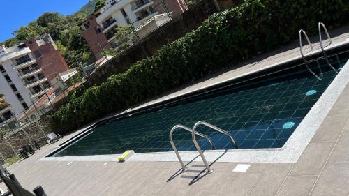 伊瓦格Hermoso Apartamento en exclusiva zona ibague Calambeo的一座大型游泳池旁设有两把金属椅