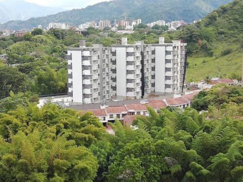 伊瓦格Hermoso Apartamento en exclusiva zona ibague Calambeo的一座树木茂密的山丘上的大型白色公寓