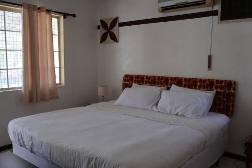 努库阿洛法'Ataongo Residence的卧室内的一张带白色床单和枕头的床