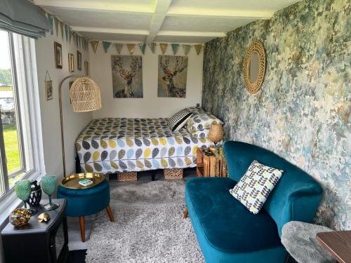 特灵Bothy hut的一间卧室配有一张床、一张沙发和一把椅子