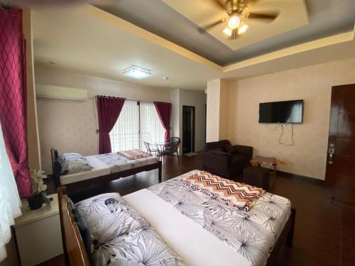 波尔多·格尼拉MinshukuKCS Hotel and Restaurant的一间带两张床和一张沙发的客厅