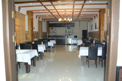 巴库AEF Hotel and Restaurants的用餐室配有白色桌子和黑色椅子