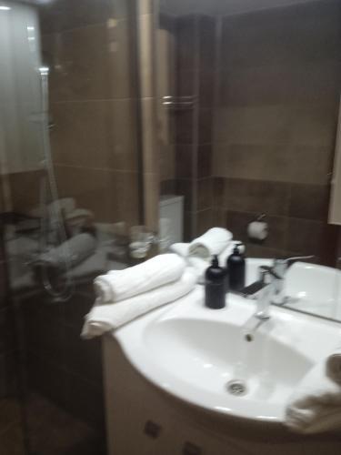 阿斯塔科斯Golden village的浴室配有盥洗盆、淋浴和毛巾