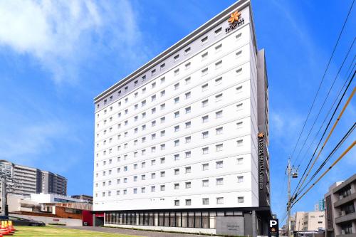 名古屋Vessel Hotel Campana Nagoya的白色的建筑,旁边标有标志