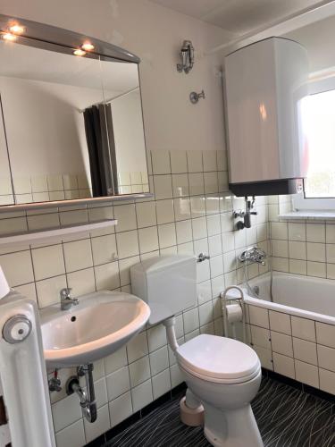 RosenfeldGäste-, Handwerkerzimmer的浴室配有卫生间、盥洗盆和浴缸。