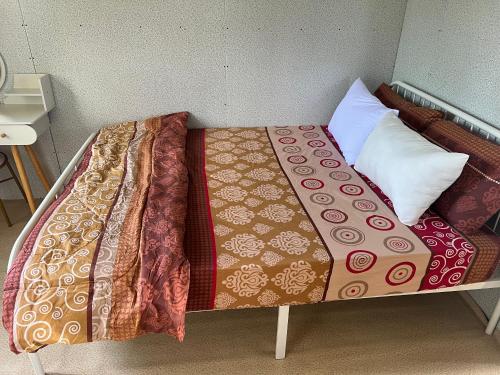 Kota BharuSafiyya Homestay的床上有毯子和枕头