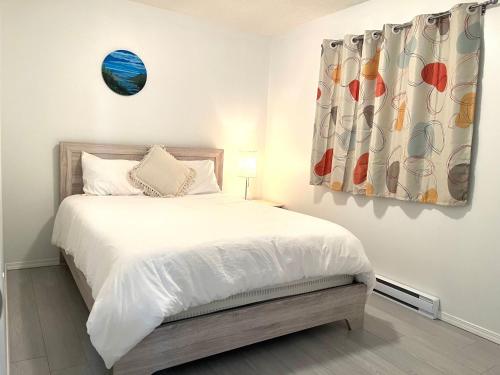 苏克Summer Breeze的一间卧室配有一张带白色床单的床和一扇窗户。